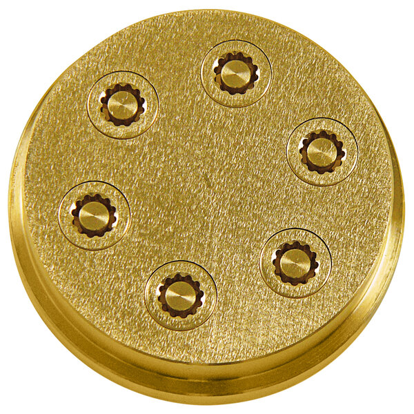 A gold circular metal die with six holes.