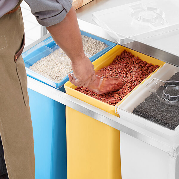 A person putting beans into a yellow Channel ingredient bin.