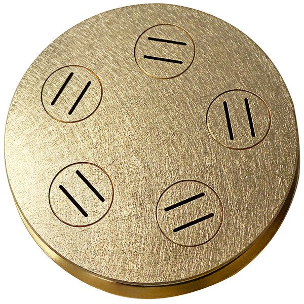 A circular gold disc with four holes in it.