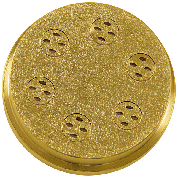 A gold metal circular pasta die with holes.