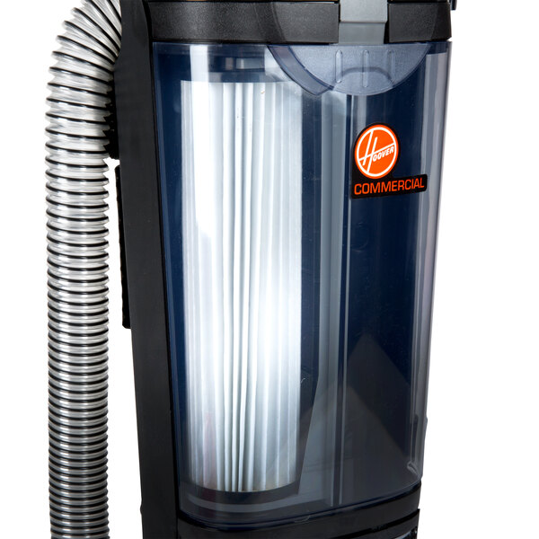 A Hoover Hush upright vacuum cleaner with a HEPA filter and hose attached.