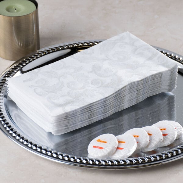 A silver tray holding a stack of white Hoffmaster Linen-Like paper guest towels.