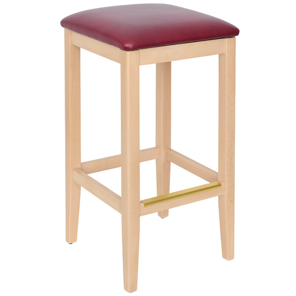 A BFM Seating wooden barstool with a burgundy vinyl seat.