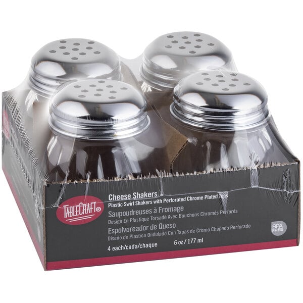 A Tablecraft pack of clear plastic swirl shakers with stainless steel tops on a counter.