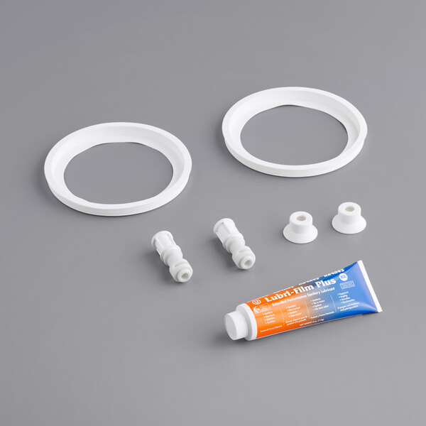 A Narvon preventative maintenance kit for a granita dispenser with white and grey plastic parts, a tube of lubricant, and white rings.