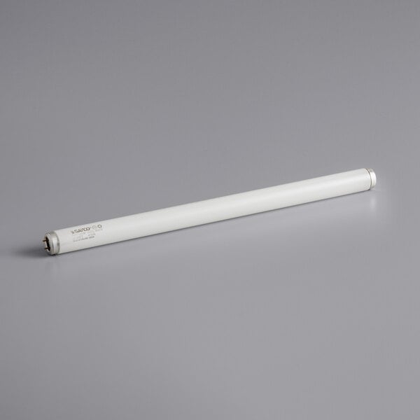 A Satco T12 20W white tube light on a gray surface.