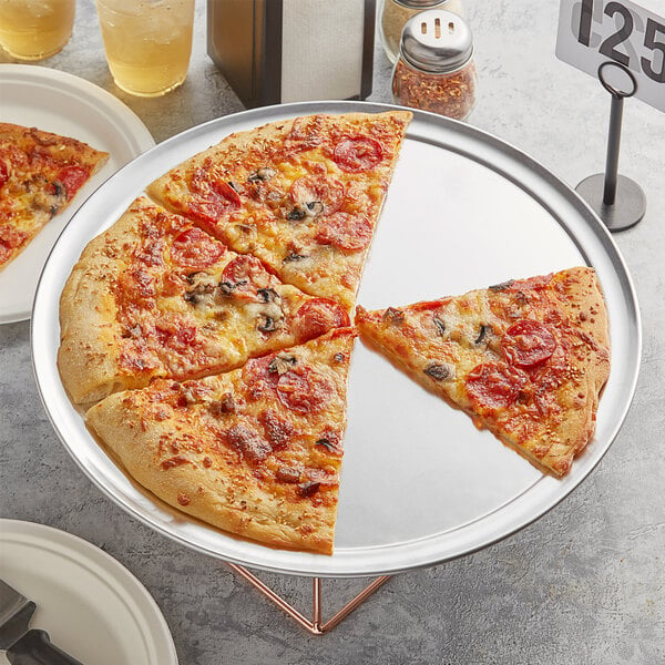 A pizza on a Choice aluminum pizza pan with two slices missing.