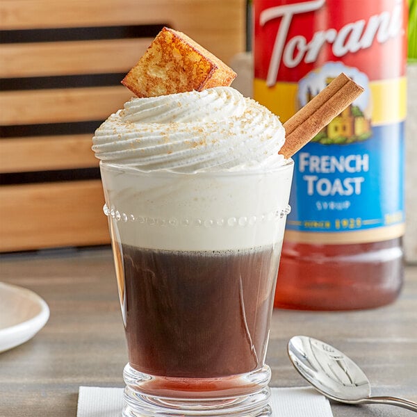 A glass of coffee with Torani French Toast flavoring syrup and whipped cream on top.