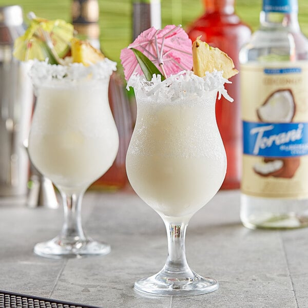 Two glasses of white tropical drinks with Torani Coconut Syrup.