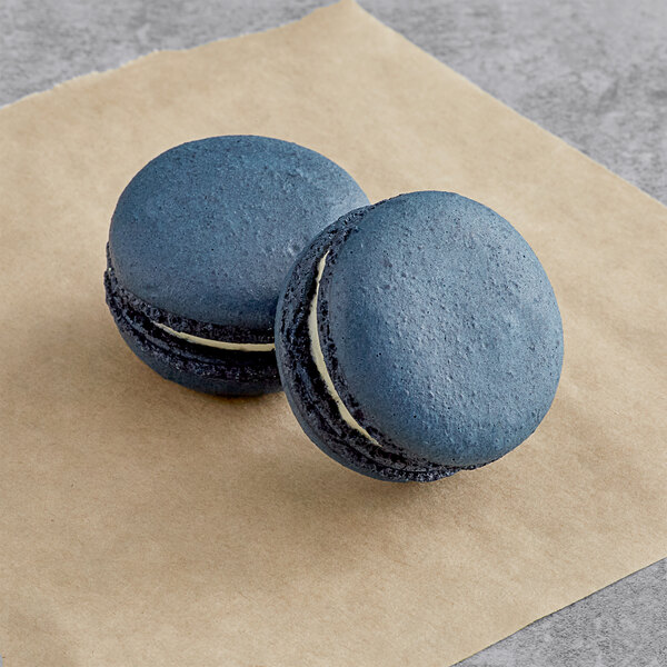 Two lavender Macaron Centrale macarons on brown paper.