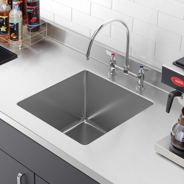 A Regency stainless steel sink bowl installed in a counter.