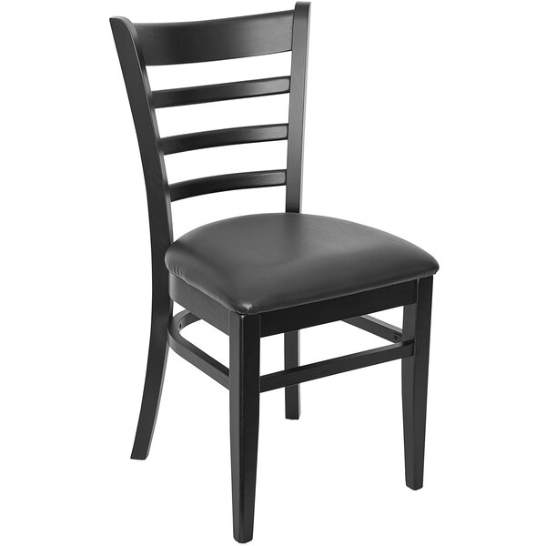 A BFM Seating black wooden ladder back side chair with a black vinyl cushion.