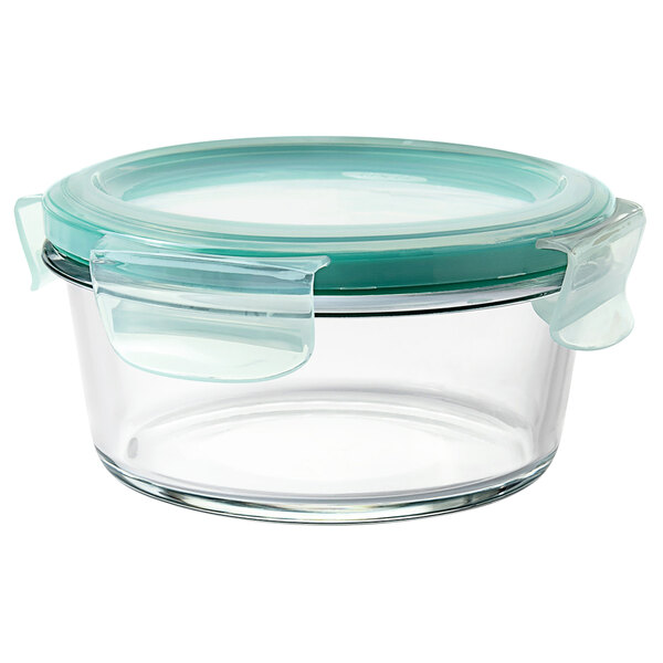 A clear round glass container with a green lid.