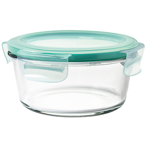 A clear glass OXO Good Grips round container with a green lid.