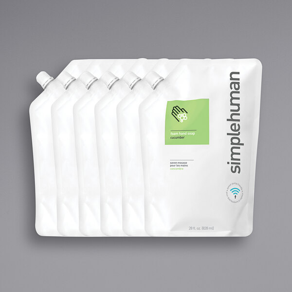 A group of white plastic bags with green and white labels for simplehuman Cucumber Scented Foam Hand Soap Refill.