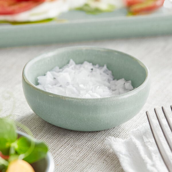 An Acopa Harbor Blue Matte Porcelain ramekin filled with white flakes.