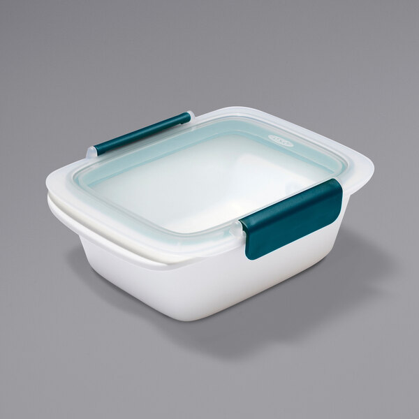 A white rectangular OXO plastic food storage container with a blue snap-on lid.