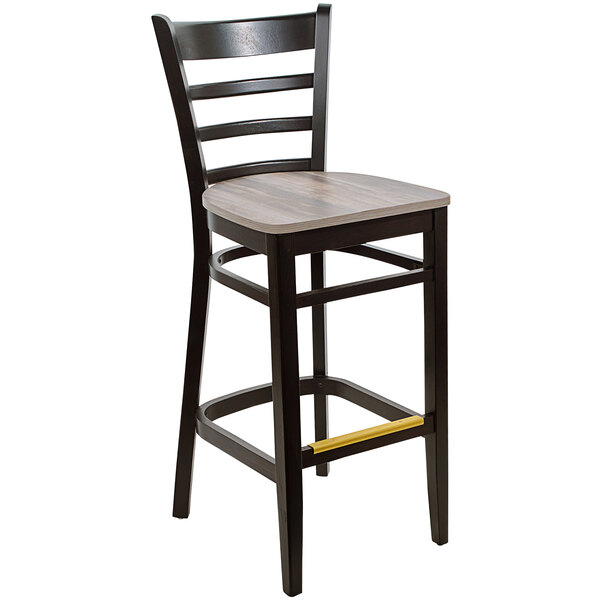 A BFM Seating black beechwood barstool with a wooden seat and black ladder back.