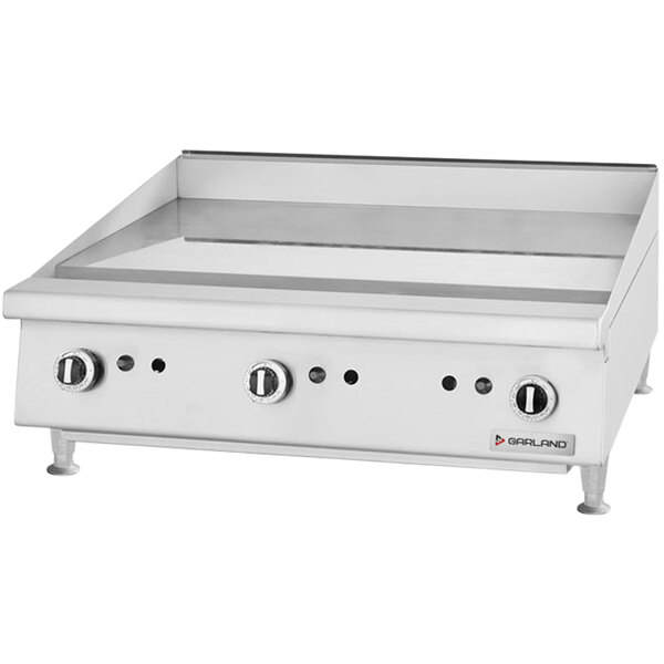 A stainless steel countertop gas griddle with manual controls and three knobs.