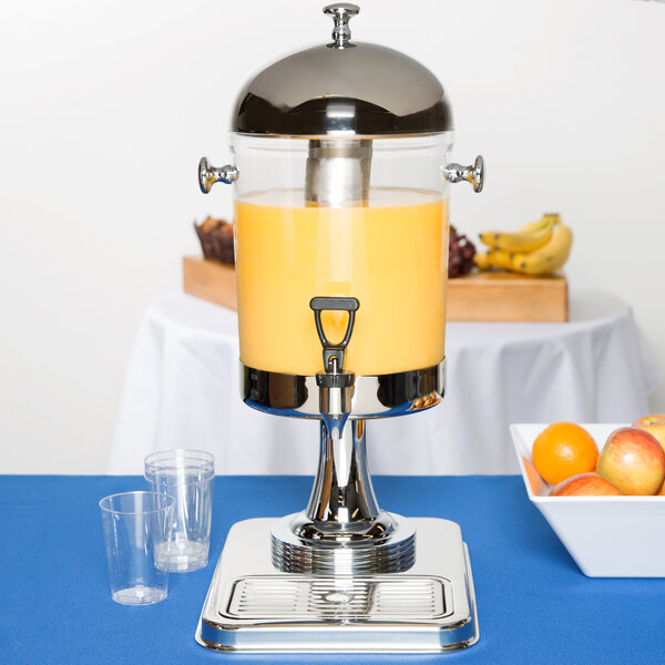 A Tablecraft cold beverage juice dispenser on a table with a clear plastic cup.