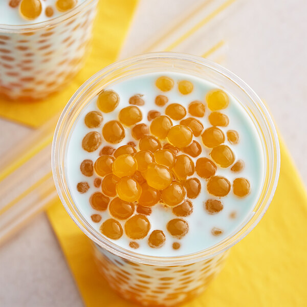 A glass of milk with orange Fanale Peach popping boba.
