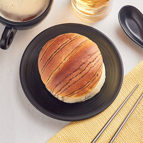 A black Acopa Izumi melamine plate with food on it next to a cup of coffee.
