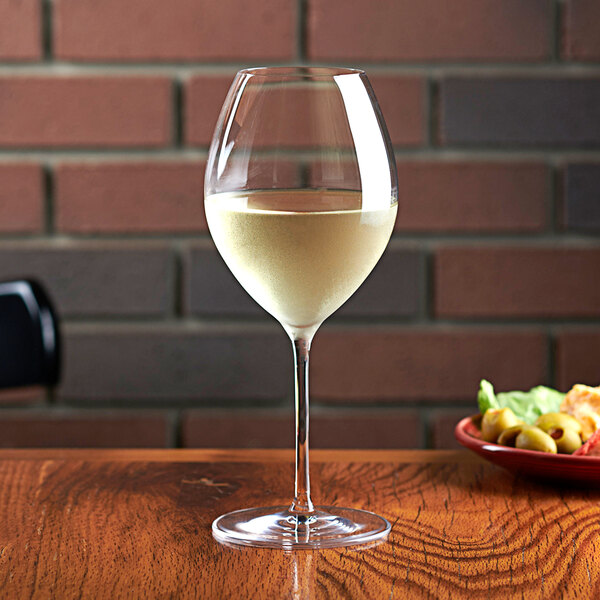 An Anchor Hocking Saporus wine glass filled with white wine on a table.