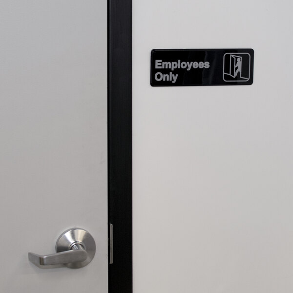 A black and white sign that says "Employees Only" on a door.