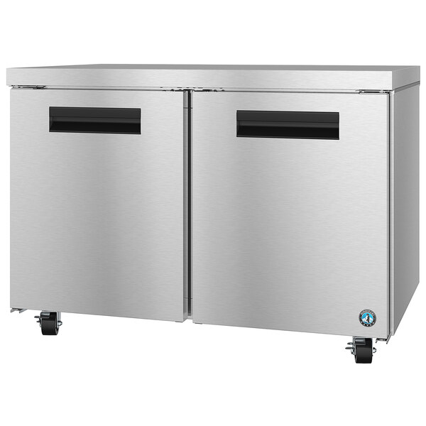 A stainless steel Hoshizaki undercounter refrigerator with black handles on a counter.
