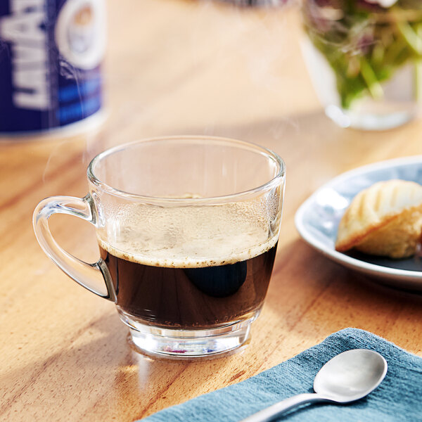 A glass of Lavazza In Blu Ground Espresso on a table with a spoon