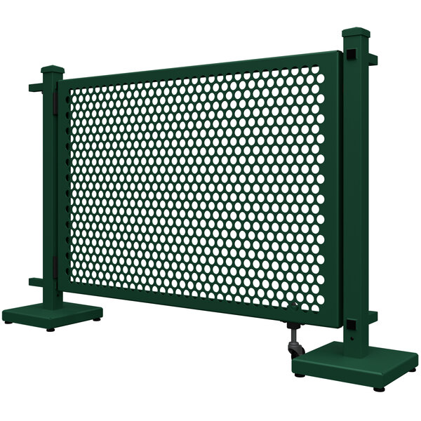 A forest green metal gate with a circle pattern and stands.