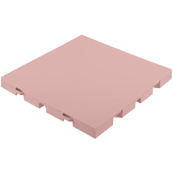 A pink plastic square EverBlock flooring tile with holes.