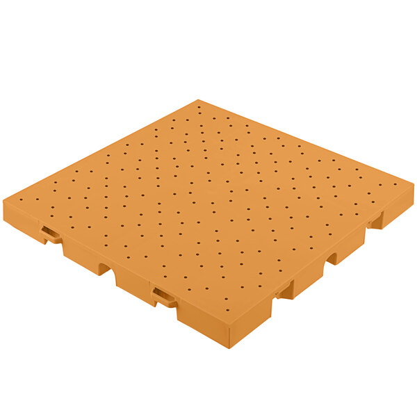 An orange plastic EverBlock flooring tile with drainage holes.