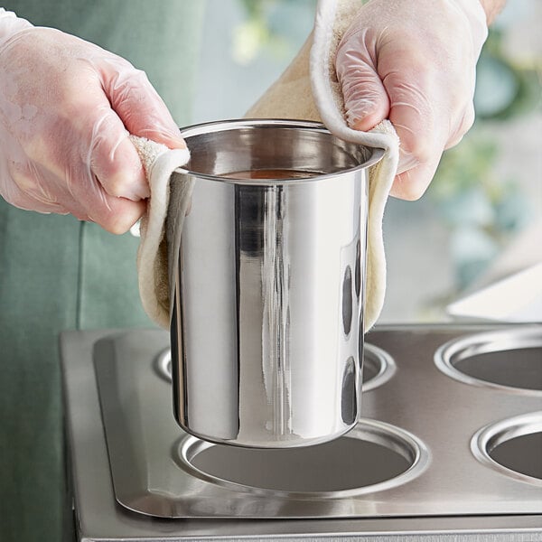 A gloved hand using a stainless steel Choice bain marie pot to hold a cup.