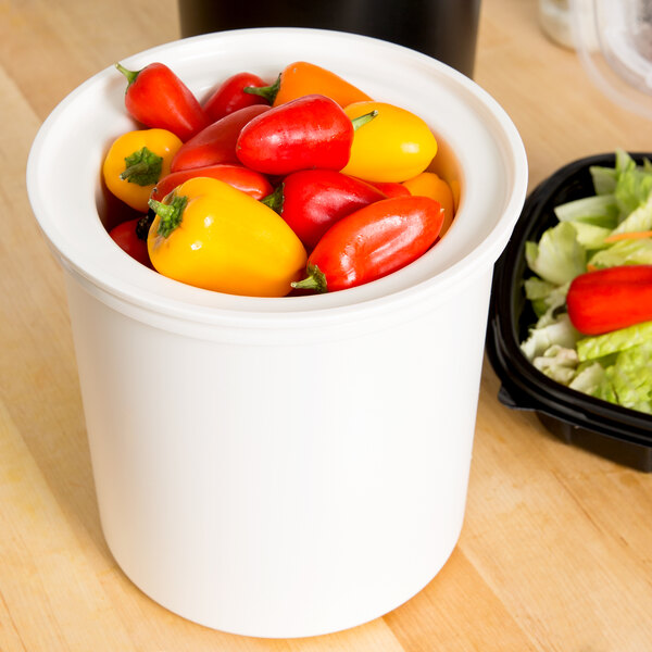 A white Cambro ColdFest crock filled with red and yellow peppers.