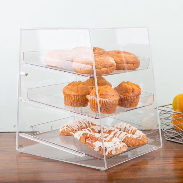 A Cal-Mil clear plastic display case with muffins and pastries inside.