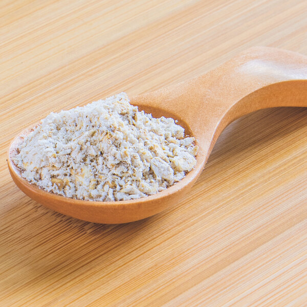 A wooden spoon filled with coarse oat powder.