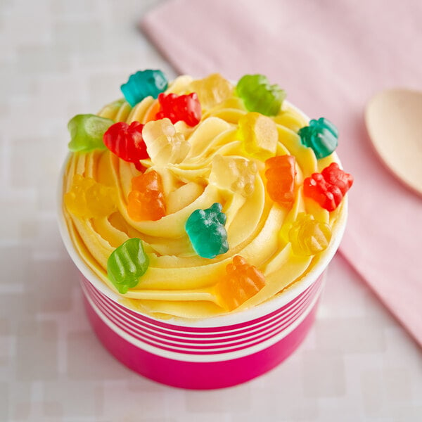 A cupcake with yellow frosting and Dutch Treat mini gummy bears on top.