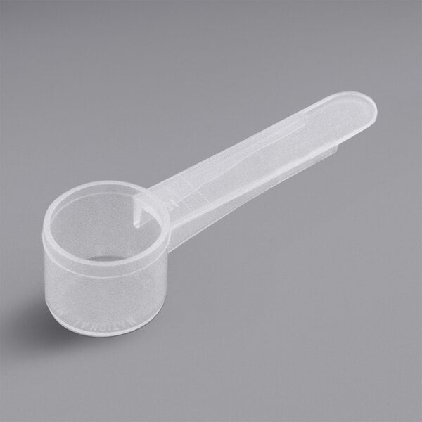 A white plastic 6 cc measuring scoop with a medium handle.
