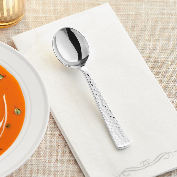 A Visions silver plastic soup spoon on a white napkin.