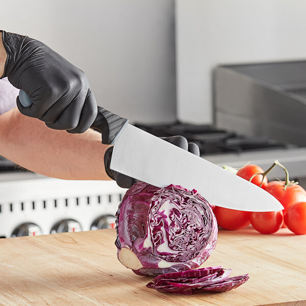 A person cutting a cabbage with a Schraf chef knife.