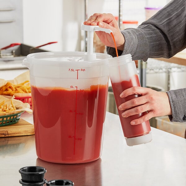 A person using a Choice condiment pump to pour red liquid into a large container.