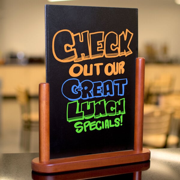 An American Metalcraft mahogany table top board with a black sign that says "Check out our great lunch specials" in colorful writing.