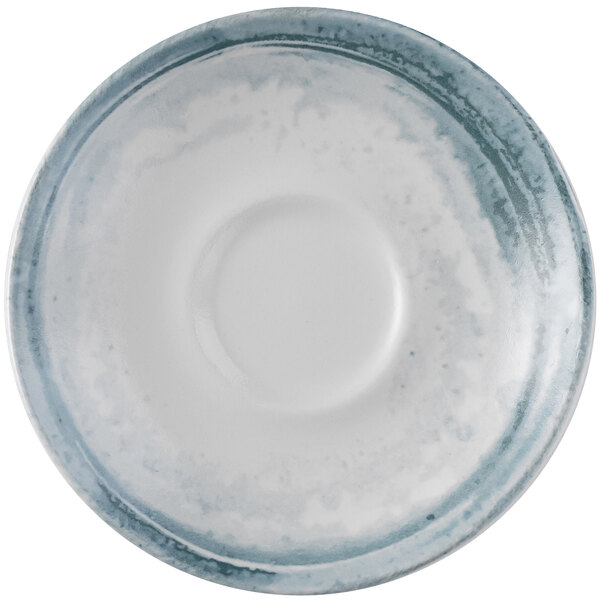 A close-up of a white Dudson Maker's Finca limestone espresso saucer with a blue and white design.