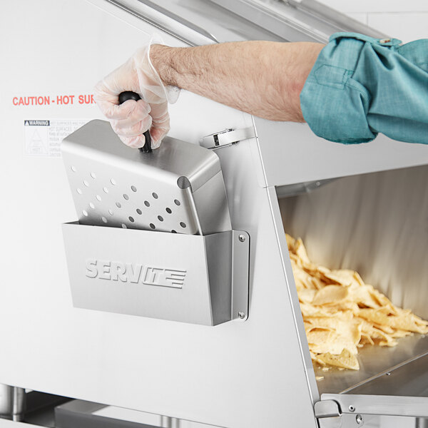 A person using a ServIt stainless steel chip scoop holder to scoop chips.
