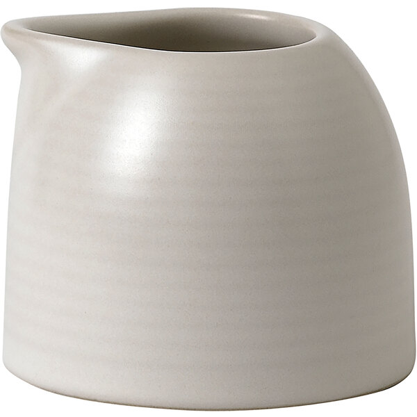 A Dudson Evo matte pearl stoneware creamer with a handle on a white surface.