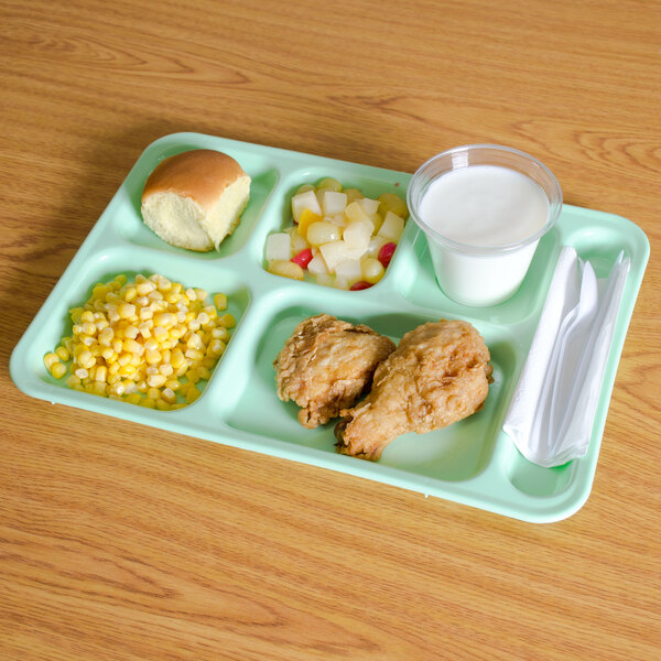 A Carlisle green 6 compartment tray with chicken, corn, a roll, and a cup of milk.