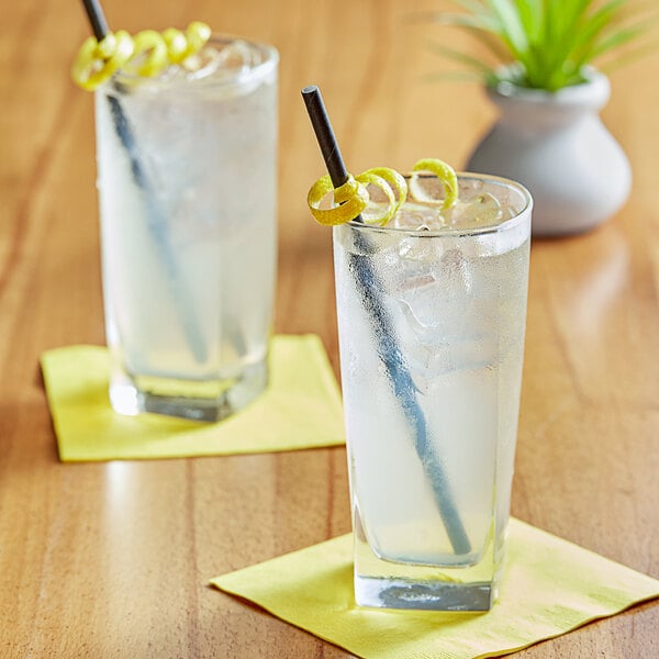 Two glasses of Tractor Beverage Co. Organic Lemonade with straws and a lemon slice.