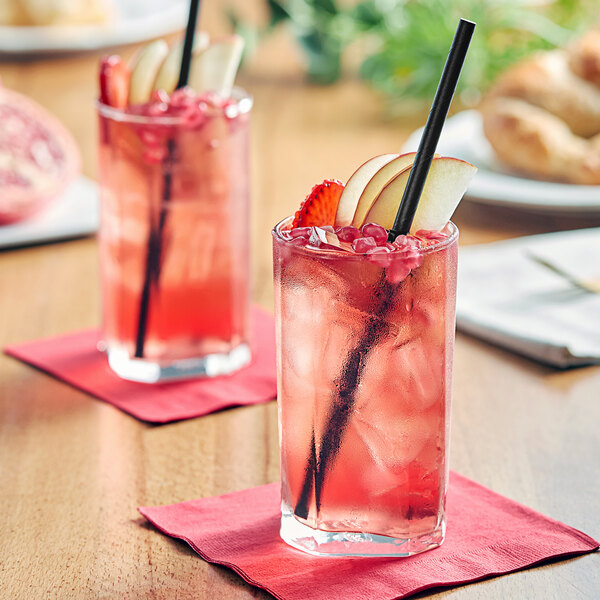 Two glasses of Tractor Beverage Co. Organic Berry Patch drink with straws and fruit.