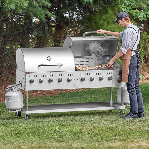 A man using a Backyard Pro stainless steel outdoor grill to cook food.